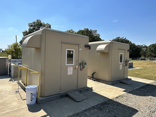 two fiberglass shelters at a waste water treatment plant